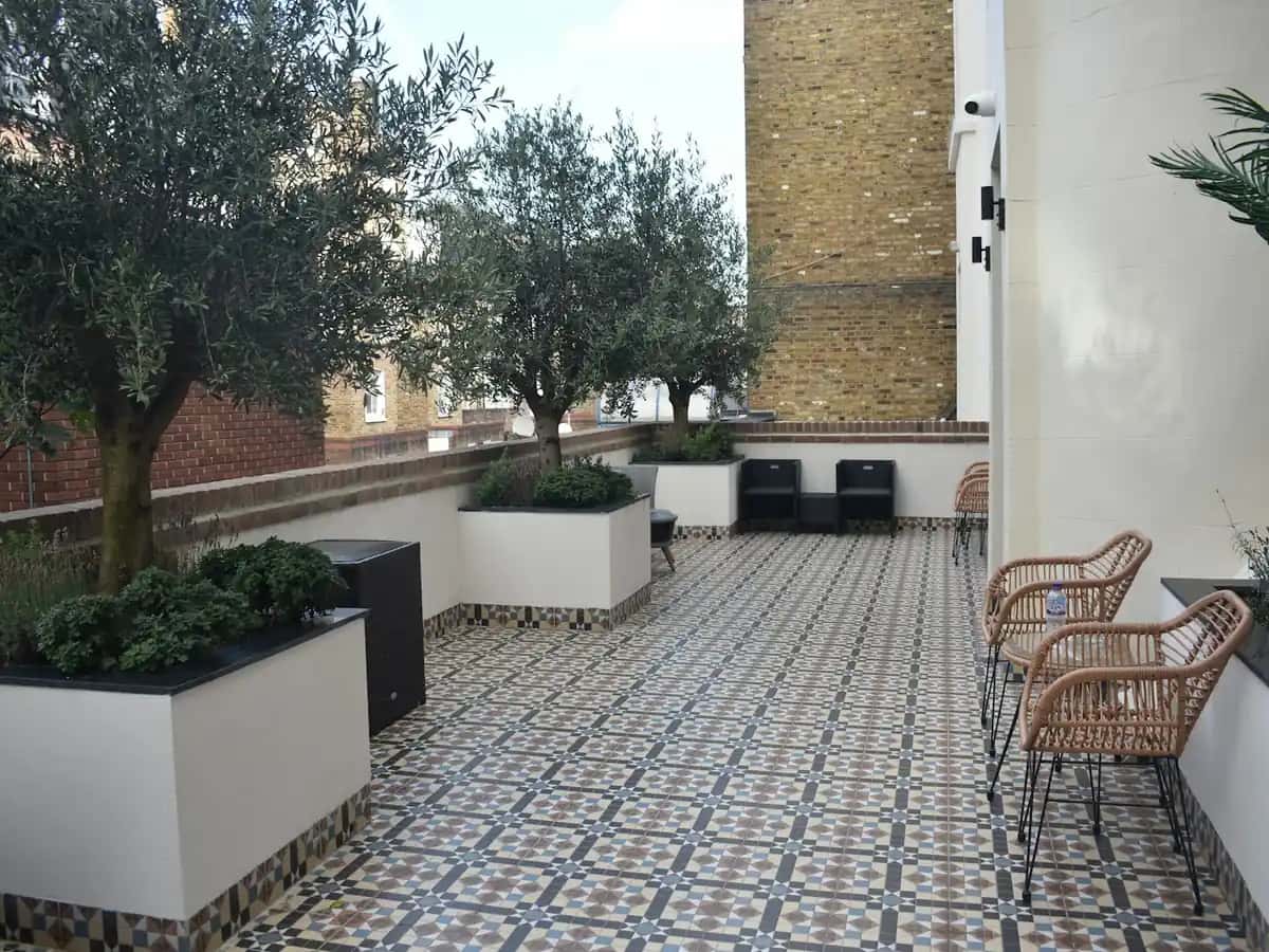 Kaplaması yenilenmiş, saksılı ağaçlarla düzenlenmiş teras